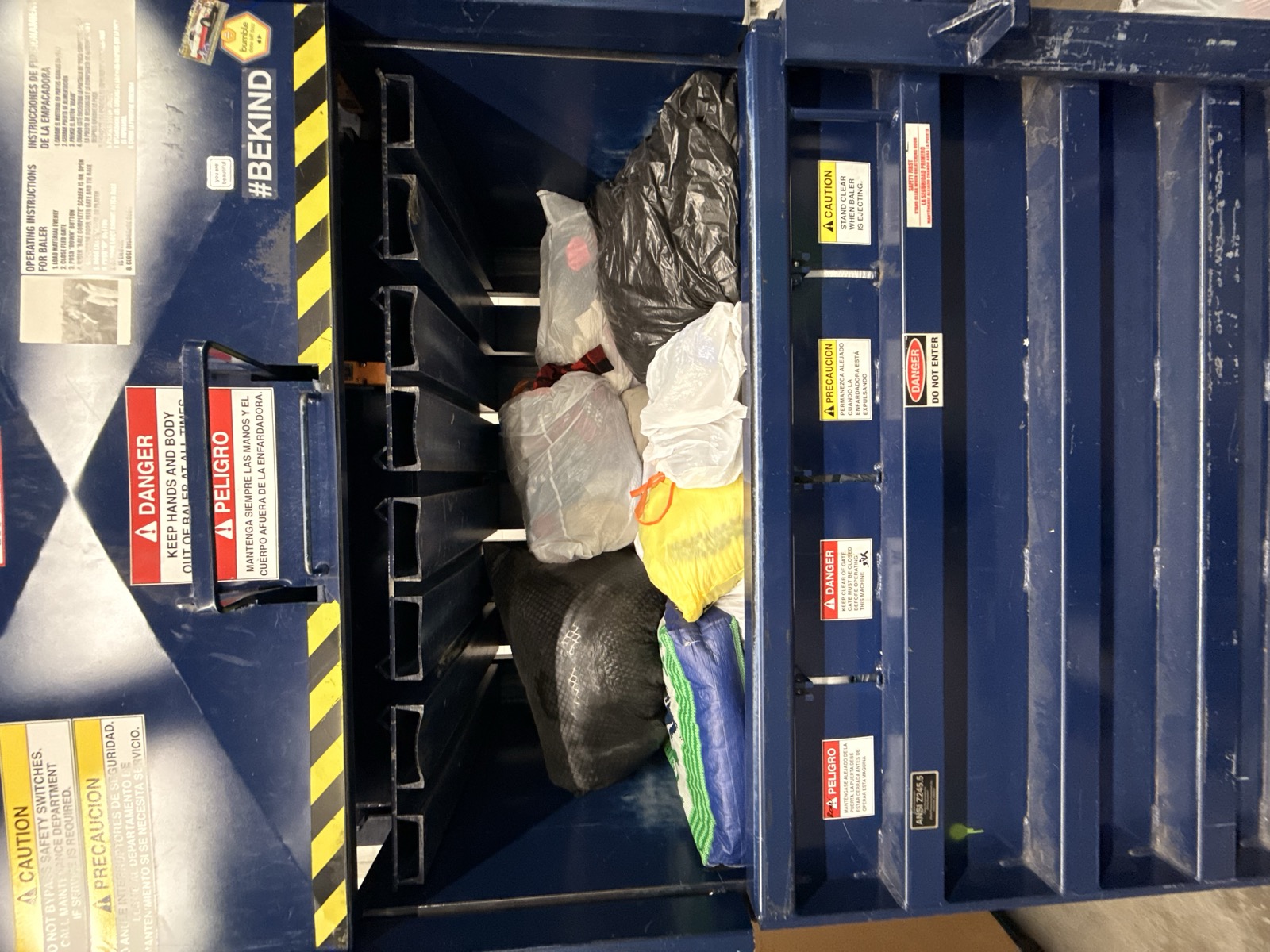 Baler machine loaded with bagged textiles