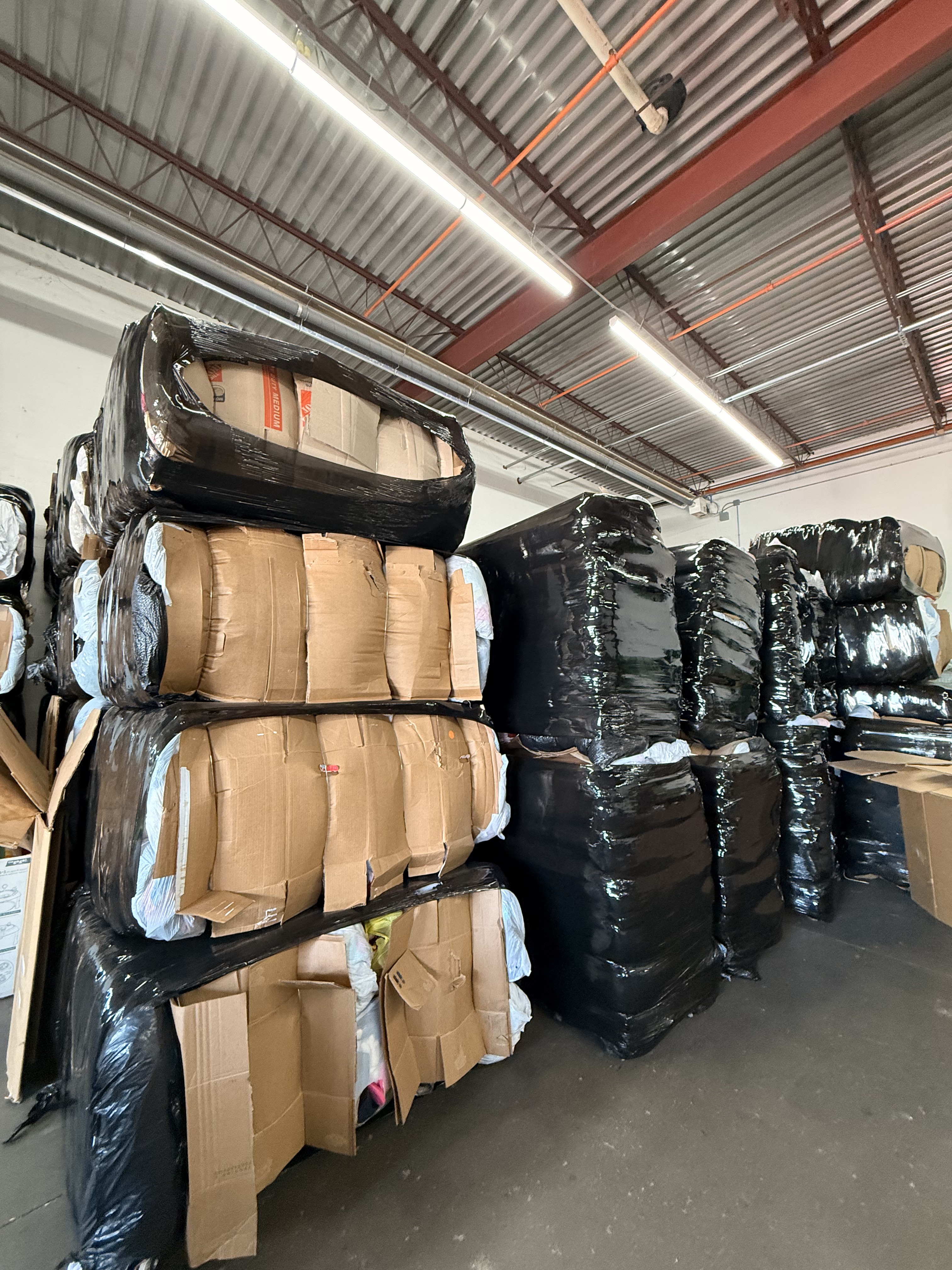 Rows of wrapped clothing bales stacked at our warehouse, ready for shipment