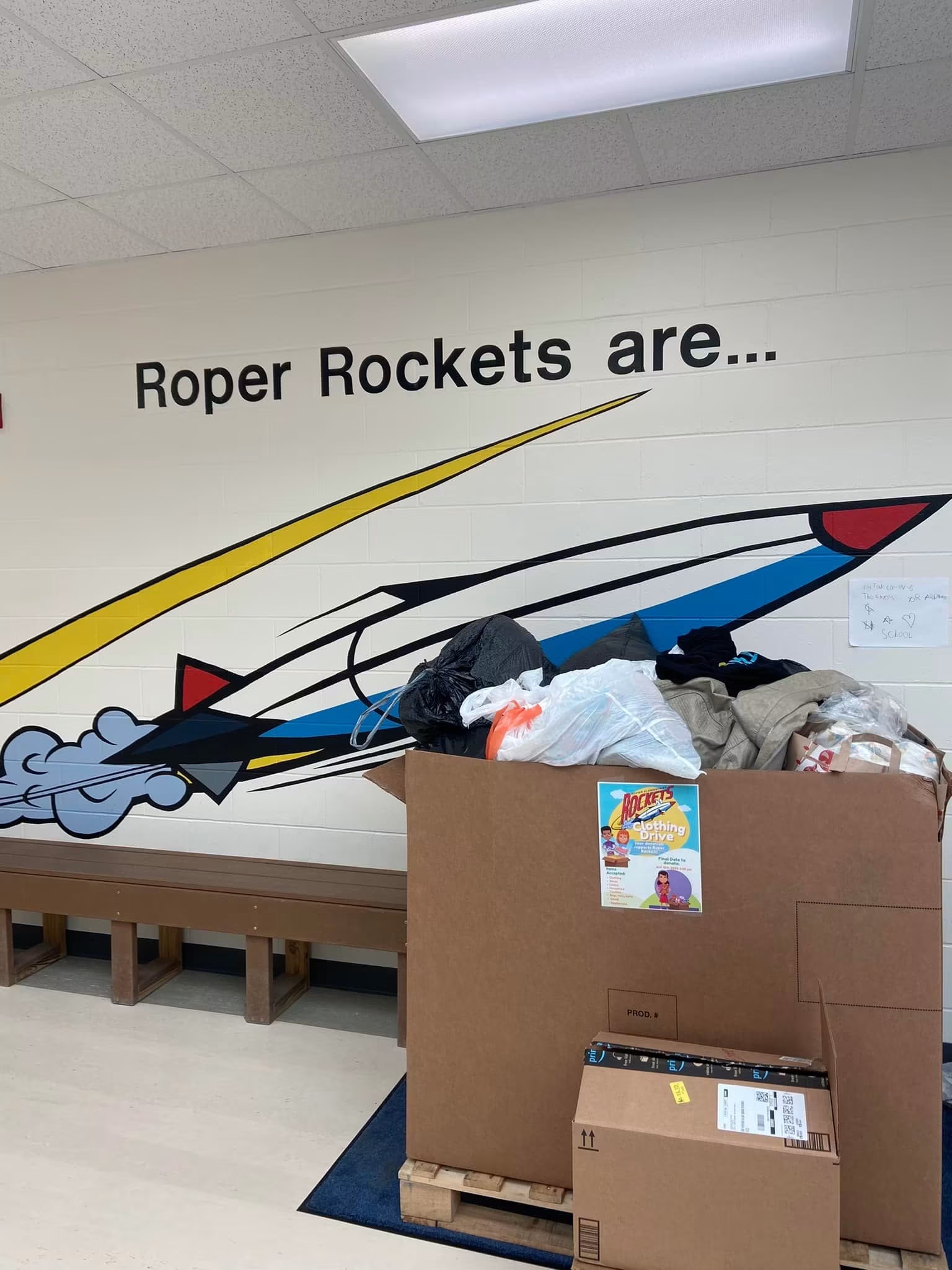 A school clothing drive donation box overflowing with coats