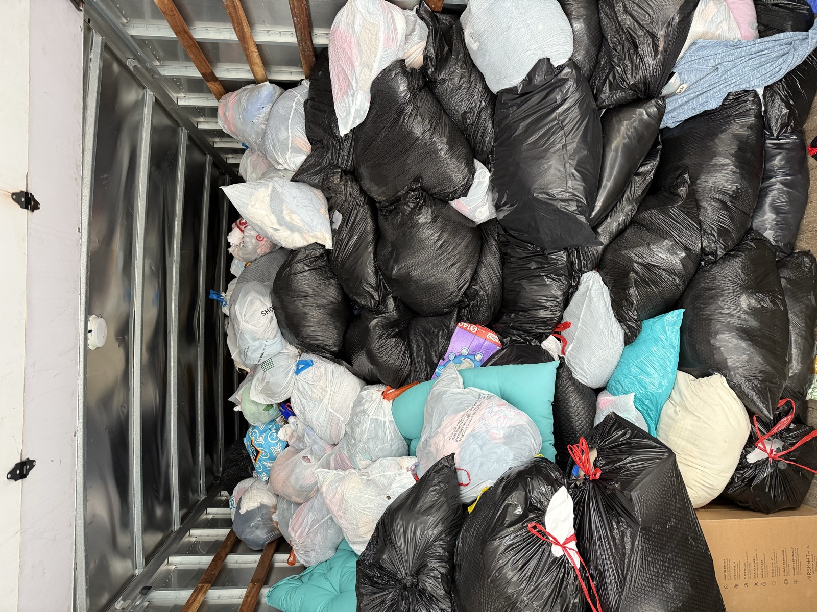 A trailer packed with bagged clothing donations, ready for processing