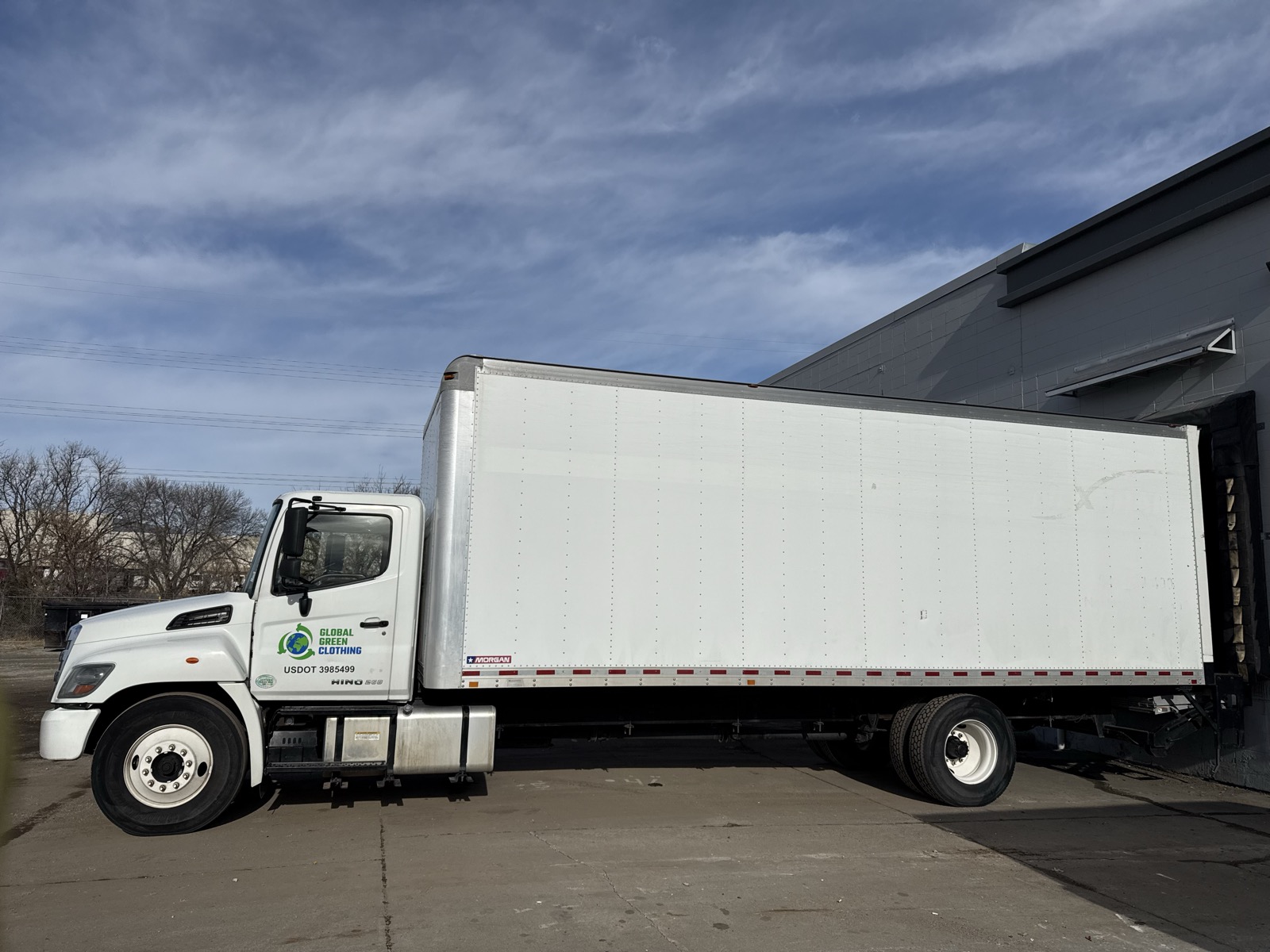 Global Green Clothing delivery truck at a warehouse loading dock